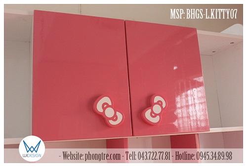 Hai cánh tủ của giá sách được sơn màu hồng và bắt tay nắm gỗ hình nơ Hello Kitty nghiêng thành hình chữ V